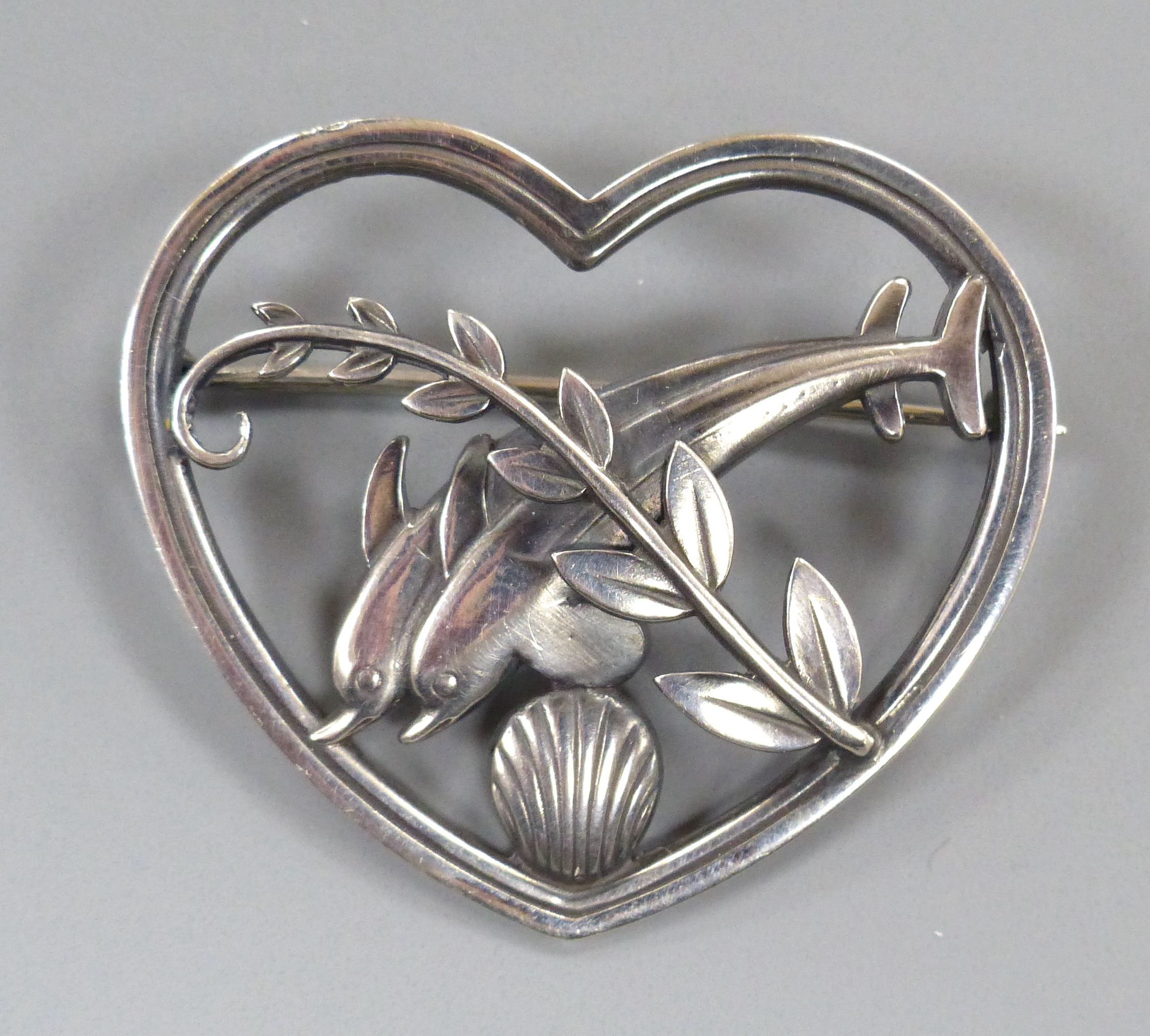 A Georg Jensen sterling heart shaped brooch, depicting twin leaping dolphins with frond, no. 312, 41mm.